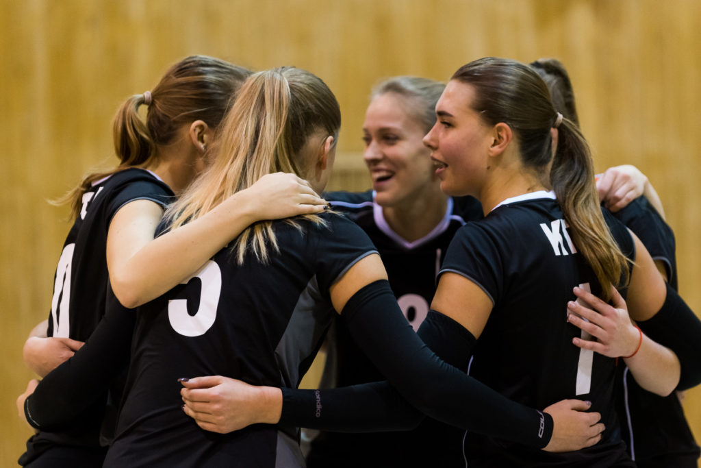 KTU women's volleyball team standing together in a circle and wrapped each other with their hands.