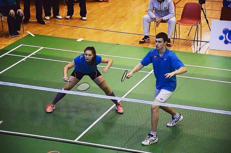 Two KTU badminton team members playing badminton ir a badminton court