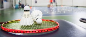 Two white badminton balls on a badminton racket