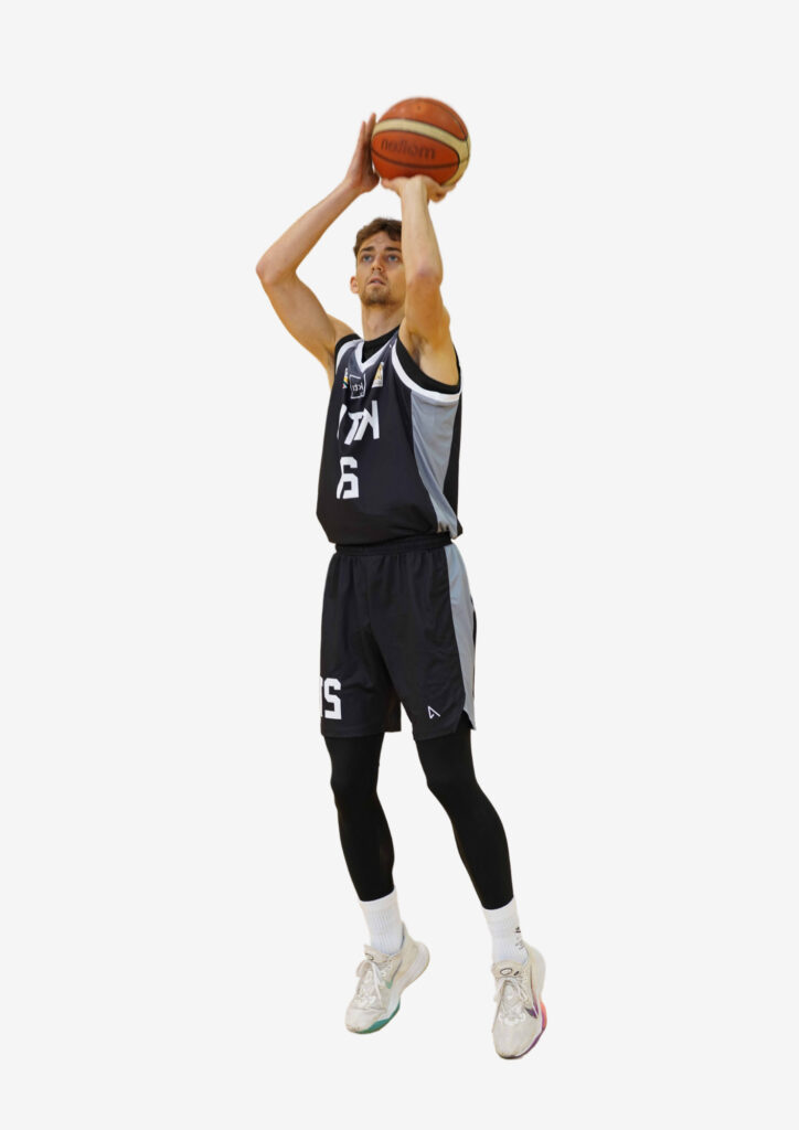 A man with blond hair and black KTU basketball jersey dunks a basketball