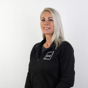A woman with blonde hair wearing a black sports jumper